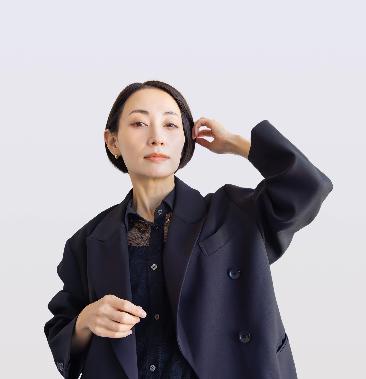 Woman adjusting her hair, wearing blazer